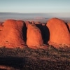 Ein großer Monolith aus rotem Fels erhebt sich aus der flachen Outback-Landschaft am Uluru, Uluru-Kata Tjuta National Park, Northern Territory © Tourism Australia