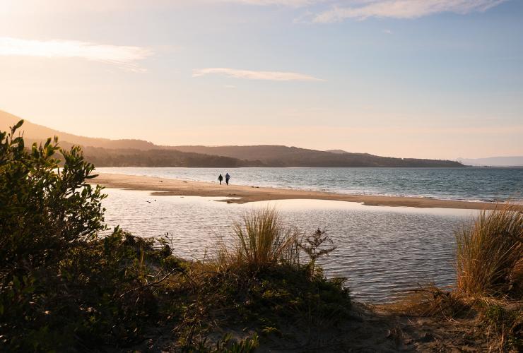 Zwei Personen gehen bei Sonnenuntergang im Sand am Meer spazieren, Adventure Bay, Bruny Island, Tasmanien © Tourism Australia